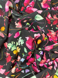 Crinkled swatch knit material in botanical black (pink flowers with green and yellow leaves on black with a slight watercolour look)
