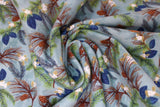 Swirled swatch winter flannel in pinecones on blue (pale blue fabric with tossed green and brown tree sprigs and pinecones, blue leaves, white floral)