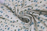 Swirled swatch winter flannel in trees on cream (cream fabric with faded cross stitch pattern and tossed tiny green and blue trees and dotted direction lines allover)