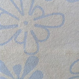 Swatch of light blue flannel fabric printed with slightly darker blue 'groovy' flowers that somewhat resemble amoebas.