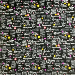 Square swatch At Home fabric (black fabric with white home related writing allover in various styles/fonts: "Home Sweet Home" "Happy home" etc. with small tossed yellow, pink and purple floral heads and dots)