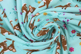 Swirled swatch jersey print fabric with woodland theme in print bambi (light blue/turquoise fabric with cartoon baby deer and small butterflies, birds, and flowers)