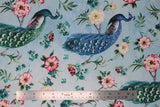 Flat swatch  feather themed print in feathered peacock (light blue fabric with blue/turquoise graceful peacocks on branches with tossed pink/white/blue floral and stems)