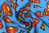 Swirled swatch superman trademark fabric (bright blue fabric with tossed red and yellow superman logos, and "Superman" text in TM font and colours)