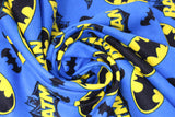 Swirled swatch batman trademark fabric (bright medium blue fabric with tossed yellow and black batman logos, black bat silhouettes, and "Batman" text with character behind, tossed allover)