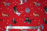 Flat swatch frisky kitty fabric (red fabric with assorted cartoon cats in white, black, grey, orange colours alone or playing together, some yarn balls, white paw prints)