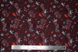 Flat swatch space printed fabric (dark burgundy fabric with tossed cartoon space related emblems: grey asteroids, orange fireballs, planets, white stars, small astronauts and spaceships, ufos)
