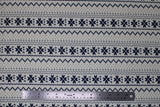 Flat swatch white winter pattern fabric (white fabric with black/navy Christmas sweater style pattern stripes with pixelated triangle design and quilt like floral repeated)