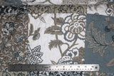 Flat swatch of matelasse printed fabric (grey floral)