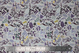 Flat swatch 100% Organic Cotton fabric (white fabric with black/purple/yellow/faded blue assorted floral pattern)