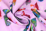 Swirled swatch migration themed printed fabric in friends in flight (light purple pastel material with colourful butterflies and birds with subtle white feathers and butterflies in background)