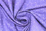 Swirled swatch migration themed printed fabric in animal tracks (dark purple fabric with tiny assorted animal tracks allover in lighter purple)