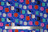 Flat swatch Pawtraits fabric (royal blue fabric with scattered doodle style cat heads in white, black, red, pink and red with tossed squares, circles and triangles in various colours)