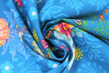 Swirled swatch medium blue fabric with shadow floral and colourful flowers and giraffes, butterflies, high heeled shoes, printed fabric