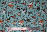 Flat swatch cat themed fabric in bike race (light blue turquoise coloured fabric with assorted cartoon cats on regular and tandem bikes)