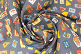 Swirled swatch cat themed fabric in pennants (charcoal grey coloured fabric with multi-coloured assorted size and shape cat related badges tossed allover)