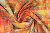 Swirled swatch Scraped Layers fabric (orange, yellow, green, rust distressed style fabric with white and yellow cross hatch/scratch look marks, subtle black text)