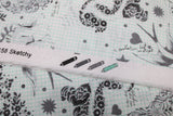 Raw hem swatch linework themed fabric in sketchy (animal and floral doodles, pandas, zebras, skunks, etc. with hearts and stars printed on white grid paper look fabric)