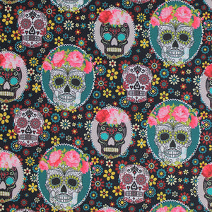 Square swatch Craneo fabric (black fabric with small yellow, blue, white and red flowers allover and assorted sugar skulls in white and black tossed, some wearing pink flower crowns and behind either white or teal oval frames)