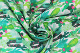 Swirled swatch Cactus fabric (white fabric with lots of layered cacti in varying styles and shades of green, some with small pink flowers)