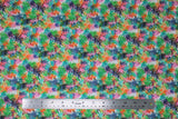 Flat swatch rainbow leaves fabric (white fabric with heavily layered tropical style leaves in black, green, blue, pink, orange ranging in levels of transparency)
