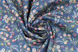 Swirled swatch Judith fabric (dark blue fabric with busy repeated floral pattern in wildflower bouquets, pink, white, green, blue flowers with greenery/stems)