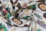 Swirled swatch auto fabric (off white fabric with pale yellow/green grid lines and tossed vintage car related emblems, green old car, tires, odometers, horns, road signs, etc. in full colour)