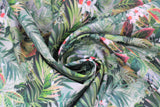 Swirled swatch Jaya fabric (layered collage of jungle greenery leaves in various shades of green, with some pink/red turning leaves and white and red floral)
