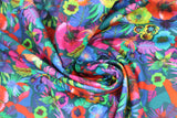 Swirled swatch Cerrado fabric (dark green/grey fabric with brightly coloured floral/jungle greenery collage allover, red, yellow, blue, pink colourway)