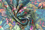 Swirled swatch Venezuela fabric (dark green fabric with busy tropical look greenery and plants layered allover with pink and purple floral, tigers and zebras and small water scenes)