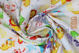 Swirled swatch Fisher-Price Main fabric (white fabric with tossed cartoon style zoo animals in full colour with multi directional colour texts in same colour (orange "orange" text, etc.) allover)