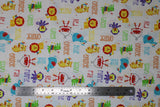 Flat swatch Fisher-Price Main fabric (white fabric with tossed cartoon style zoo animals in full colour with multi directional colour texts in same colour (orange "orange" text, etc.) allover)