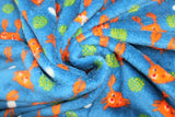 Swirled swatch (side 2) Poulpy fabric (blue fabric with tossed smiling orange cartoon style crabs with arms up, loosely scattered white dots and green dot clusters)
