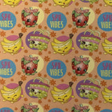 Square swatch Shopkins fabric (light/medium orange circles fabric tossed fruit, and "SPK VIBES" pink/yellow text)