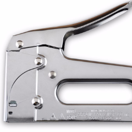 Slightly cropped image of a silver staple gun, trigger arching up and to the right above the rounded grip.  Some faint, illegible text is etched into the bottom edge of the handle.