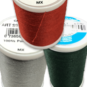 A closeup of thread spools in red, grey and green