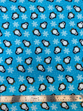 Flat swatch winter themed flannel in Penguins (cartoon penguins and snowflakes on light blue)