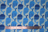 Flat swatch whale hello there fabric (off white/lightest blue fabric with lines of smiling cartoon blue whales with stripes, polka dot, and chevron designs)