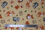 Flat swatch forest friends fabric (tan fabric with tossed cartoon forest creatures in full colour: racoon, fox, squirrel, deer, owl, tossed green leaves, brown and red mushrooms, brown and green acorns)