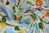Swirled swatch zoo fabric (white fabric with busy zoo style design tossed cartoon animals and green leaves allover. Full colour turtles, aligators, lions, zebras, parrots, toucans, elephants, etc.)