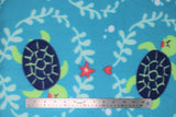 Flat swatch sea turtles fabric (light/medium blue fabric with tossed navy and green cartoon sea turtles eyes closed with light blue ocean greenery look circular frames around and tossed pink starfish and hearts)