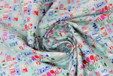 Swirled swatch make today awesome fabric (pale light blue/green fabric with text allover going horizontally and vertically, in white, blue, red, purple and green with inspirational text including "make today awesome")