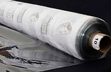 A partly unfurled roll of clear soft vinyl with white backing paper covered in black motifs. The end of the roll has a label with a 10 on it.