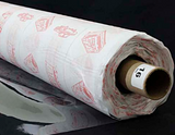A partly unfurled roll of clear soft vinyl with white backing paper covered in red motifs. The end of the roll has a label with a 16 on it.