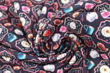 Swirled swatch hot cocoa fabric (black fabric with tossed mugs of hot cocoa in many different styles: with and without saucers, whipped cream, white mugs, pink mugs, blue mugs, red mugs, clear mugs, some in small black badges with red outlines and tossed candy canes)