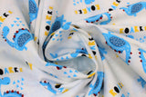 Swirled swatch Dino Roarrr fabric (white fabric with tossed blue cartoon style dinosaurs with "ROARRR" text in black, yellow and blue)