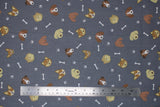Flat swatch dog bones fabric (medium grey fabric with tossed white dog bones and paw prints, and tossed cartoon dog heads in tan, white and brown shades and different breed/styles)