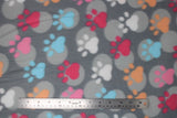 Flat swatch colourful paws grey fabric (dark grey fabric with light grey large polka dots and white, blue, pink, magenta and orange large paw prints)