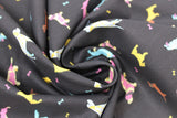 Swirled swatch assorted black fabric (black fabric with tossed small assorted cartoon dogs and tiny bones in yellow, blue, pink colourway with brown weiner dogs)