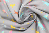 Swirled swatch assorted grey fabric (grey fabric with tossed small assorted cartoon dogs and tiny bones in yellow, blue, pink colourway with brown weiner dogs)